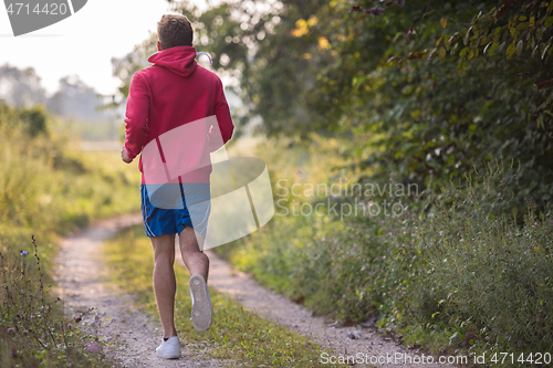 Image of man jogging along a country road