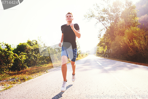 Image of man jogging along a country road