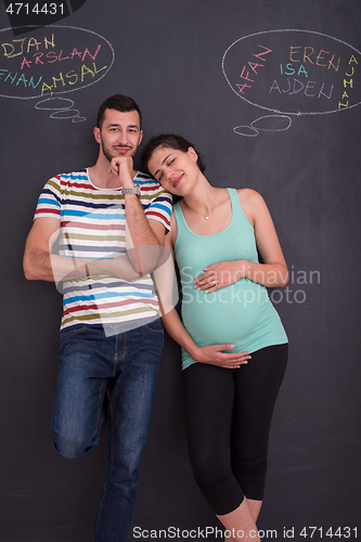 Image of pregnant couple writing on a black chalkboard