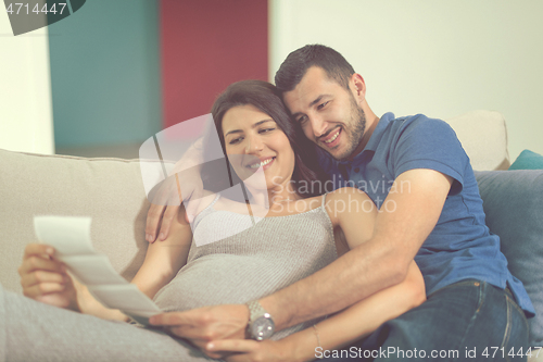 Image of pregnant couple looking baby\'s ultrasound