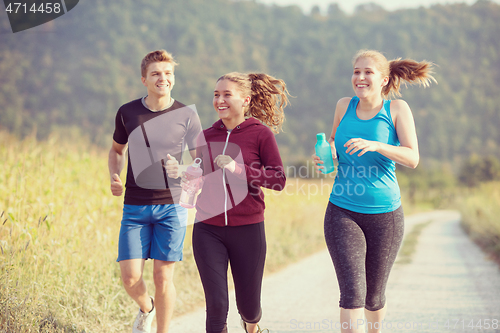 Image of young people jogging on country road