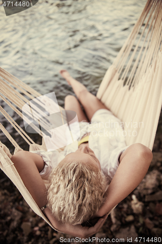 Image of blonde woman resting on hammock