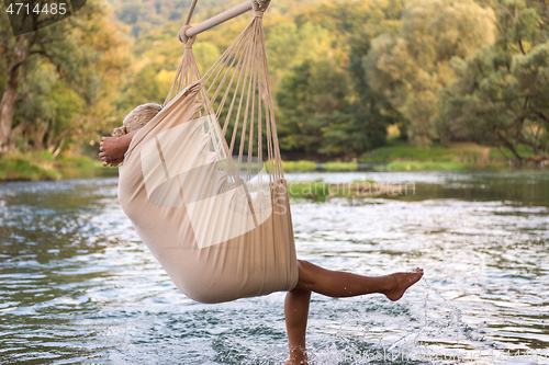 Image of blonde woman resting on hammock