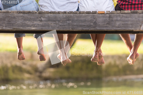 Image of people sitting at wooden bridge