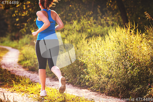 Image of woman jogging along a country road