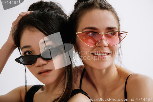 Image of Two young female ballet dancers against white studio background