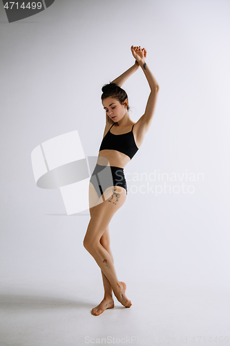 Image of Young female ballet dancer against white studio background