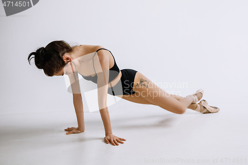 Image of Young female ballet dancer against white studio background