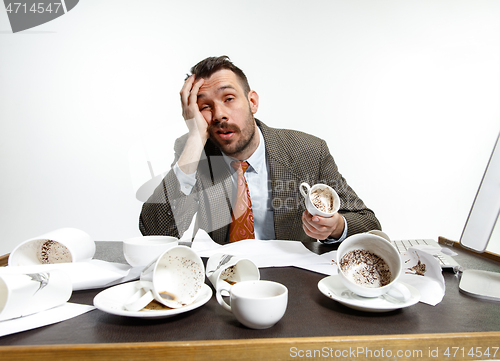 Image of Young man drinking a lot of coffee