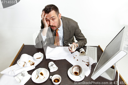 Image of Young man drinking a lot of coffee