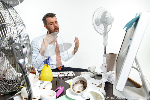 Image of Young man ssuffering from the heat in the office