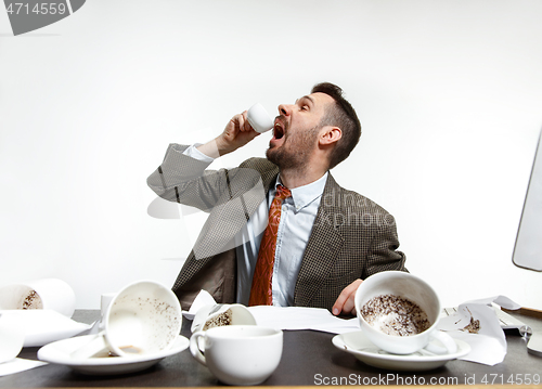 Image of Young man drinking a lot of coffee