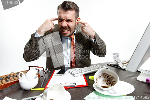 Image of Young man suffering from the talks in the office