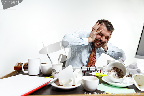 Image of Young man suffering from the noise in the office