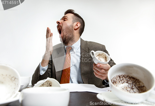 Image of Young man drinking a lot of coffee