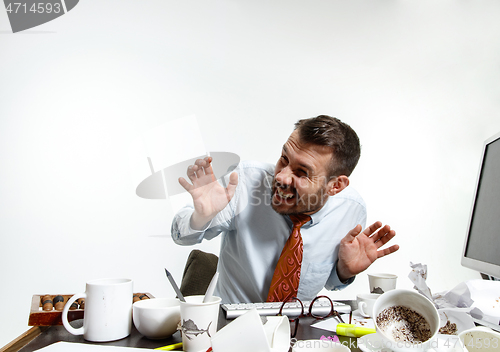 Image of Young man suffering from the noise in the office