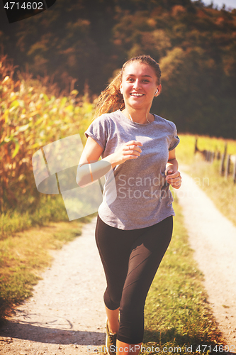 Image of woman jogging along a country road