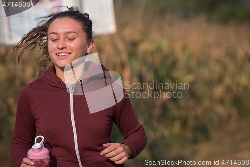 Image of woman jogging along a country road