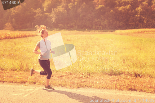 Image of woman jogging along a country road