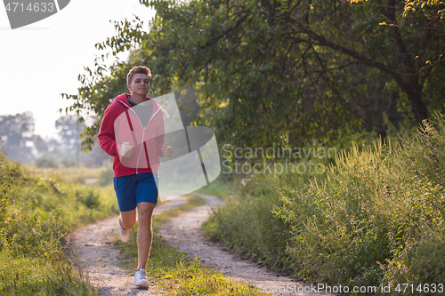 Image of man jogging along a country road