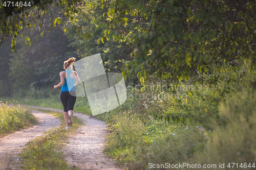 Image of woman jogging along a country road