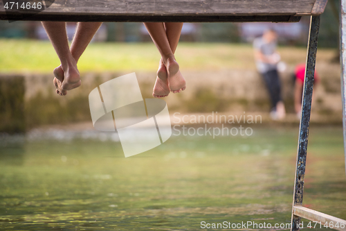 Image of people sitting at wooden bridge