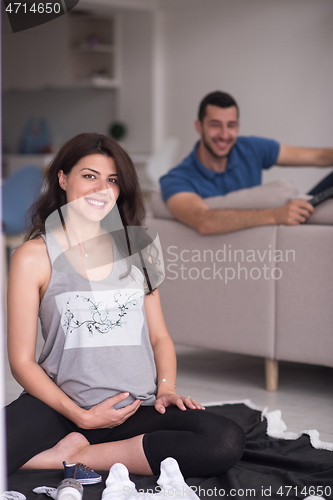 Image of pregnant couple checking a list of things for their unborn baby