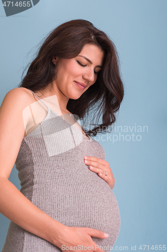Image of Portrait of pregnant woman over blue background