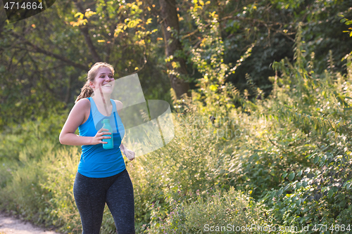 Image of woman jogging along a country road