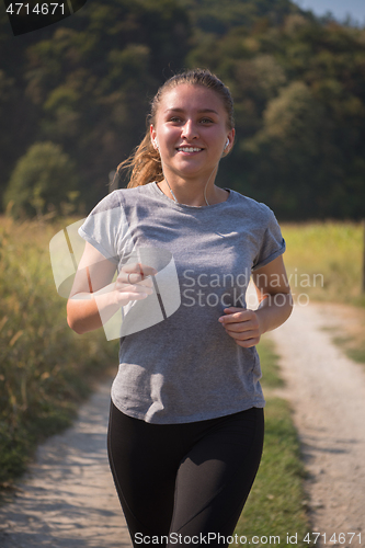 Image of woman jogging along a country road
