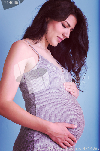 Image of Portrait of pregnant woman over blue background