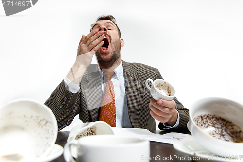 Image of Young man drinking a lot of coffee