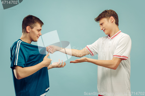 Image of Two young men isolated on blue background