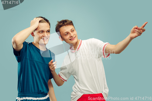 Image of Two young men isolated on blue background