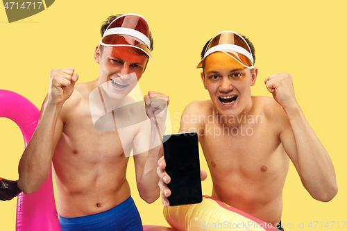 Image of Two young men isolated on yellow studio background