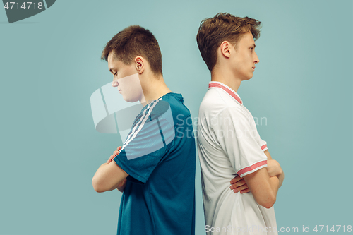 Image of Two young men isolated on blue background