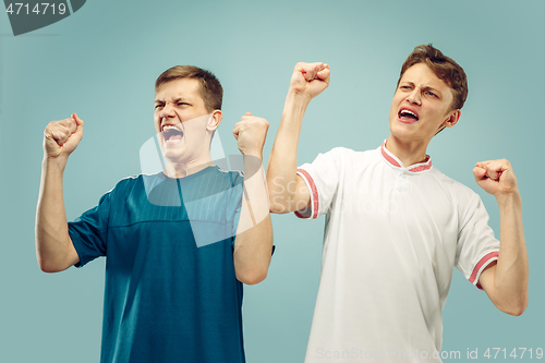 Image of Two young men isolated on blue background