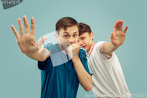 Image of Two young men isolated on blue background