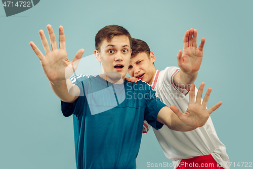 Image of Two young men isolated on blue background