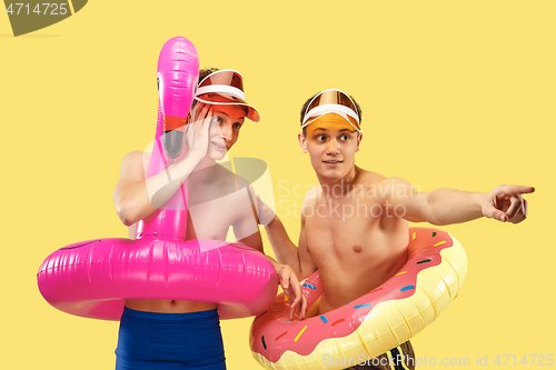 Image of Two young men isolated on yellow studio background