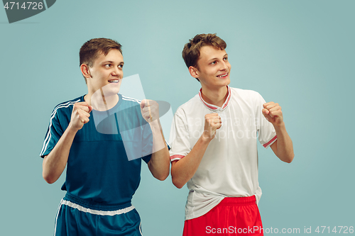 Image of Two young men isolated on blue background