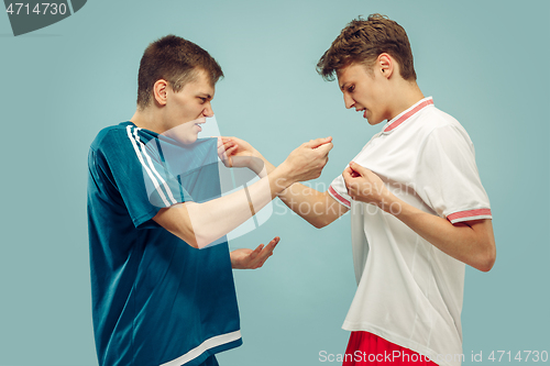 Image of Two young men isolated on blue background