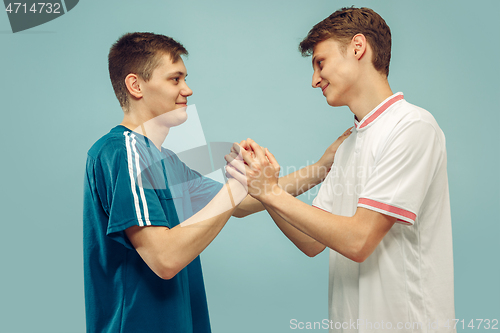 Image of Two young men isolated on blue background