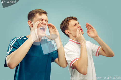 Image of Two young men isolated on blue background