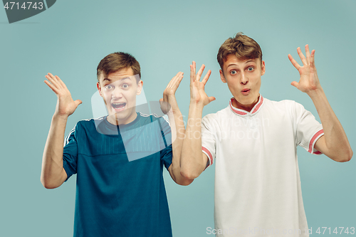 Image of Two young men isolated on blue background