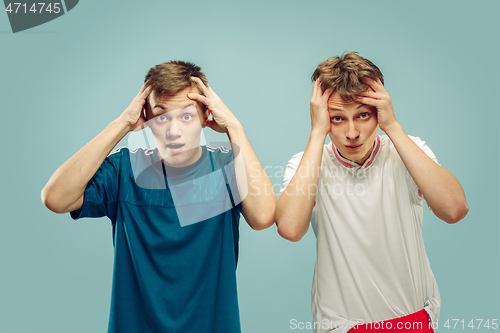 Image of Two young men isolated on blue background