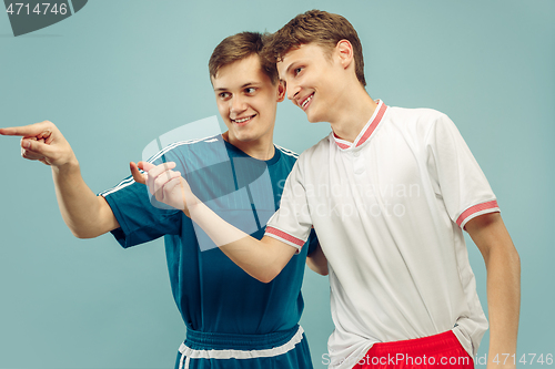 Image of Two young men isolated on blue background