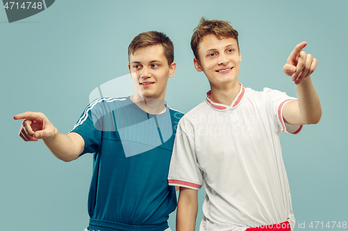 Image of Two young men isolated on blue background