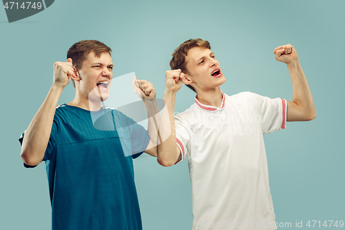 Image of Two young men isolated on blue background