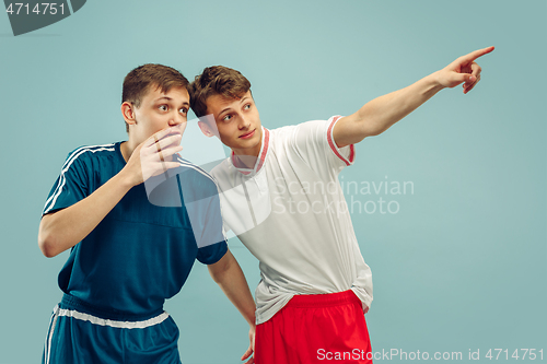 Image of Two young men isolated on blue background